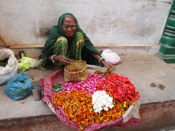 an Indian woman selling flower blossoms