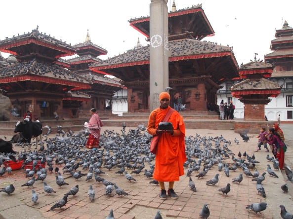 a monk stands silently seeking alms in front of Jagannath Mandir